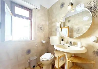 a bathroom with a sink and a mirror and a toilet at Solemar Sicilia - Ville Paradiso in Santa Flavia