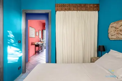 a bedroom with a bed and a blue wall at Verosicily Panoramic House with access to the sea in Terrasini