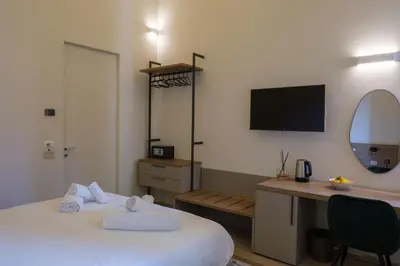 a hotel room with a bed and a desk and a tv at Vissi d'Arte Rooms in Palermo