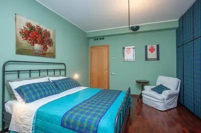 a blue bedroom with a bed and a chair at Casa Adele in Palermo