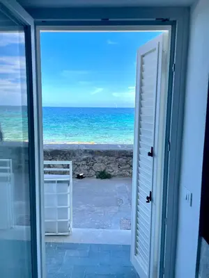 an open door to a view of the ocean at Una Finestra sul Mare in Palermo