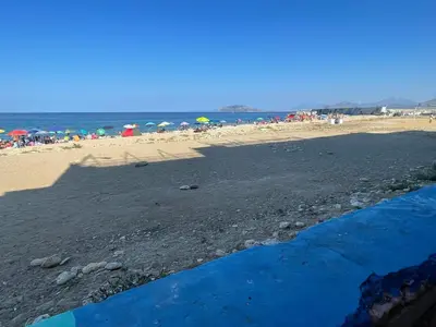 a beach with umbrellas and people on the beach at Una Finestra sul Mare in Palermo
