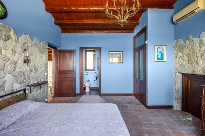 a large room with a bed and a stone wall at Verosicily Villa Glicine in Termini Imerese