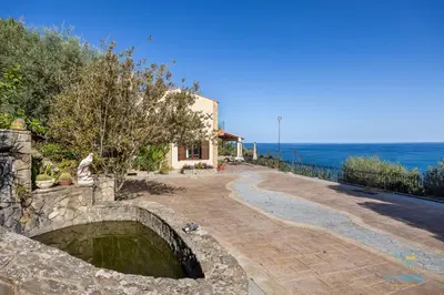 a stone path leading to a house with the ocean at Verosicily Villa Glicine in Termini Imerese
