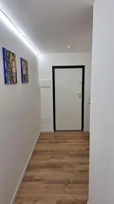 a white room with a door and a wooden floor at Casa Salina Suite in Palermo