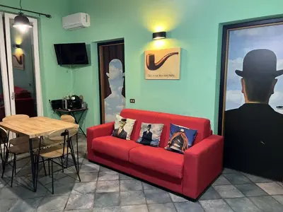 a living room with a red couch and a table at Le Stanze di Magritte in Palermo