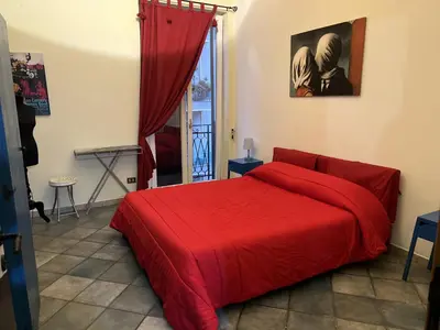a bedroom with a red bed with a red blanket at Le Stanze di Magritte in Palermo