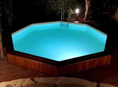 a hot tub with blue lighting in a backyard at night at Casa Mary in Castellammare del Golfo