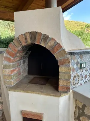 an outdoor pizza oven with a brick at Stella Del Mare in Scopello