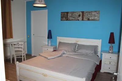 a bedroom with a bed with a blue wall at Locanda Del Drago in Monreale