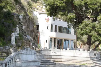 a white building with a statue in front of it at Locanda Del Drago in Monreale