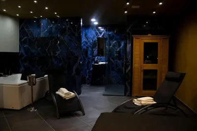 a bathroom with blue marble walls and a sink at Dea Suite in Bagheria