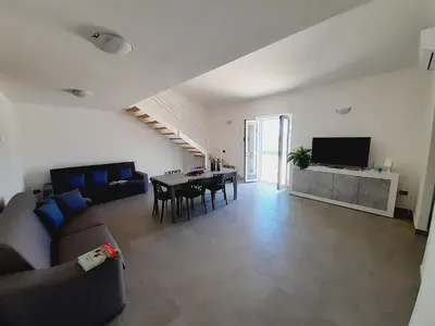 a living room with a couch and a table at Campofelice Holidays East Villa in Campofelice di Roccella