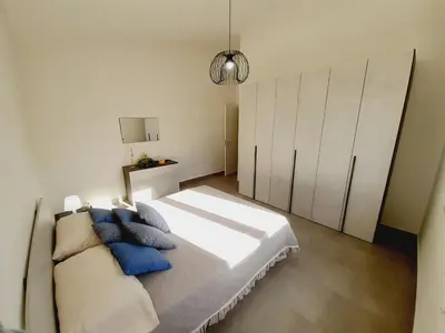 a bedroom with a large bed with blue pillows at Campofelice Holidays East Villa in Campofelice di Roccella