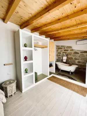 a bathroom with a bath tub and a stone wall at Duplex Townhouse with Gigantic Terrace in Palermo