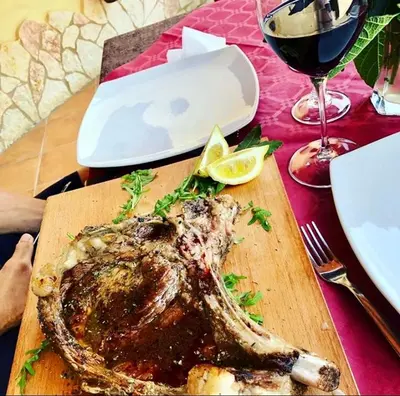 a fish on a cutting board next to a glass of wine at Agriturismo Tenute Pispisa Segesta in Calatafimi