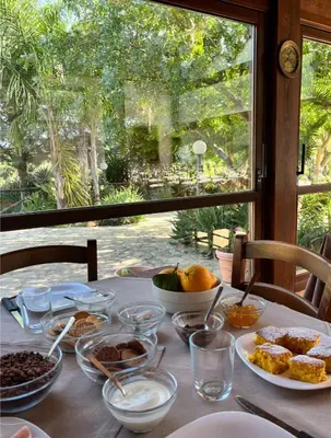 a table with plates of food and a window at Agriturismo Tenute Pispisa Segesta in Calatafimi