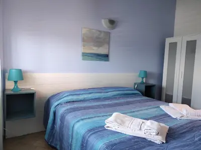 a bedroom with a bed with towels on it at Bellavista Apartments in Scopello