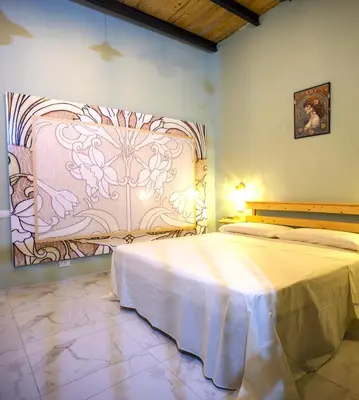 a bedroom with two beds and a painting on the wall at Normanni Underground in Palermo