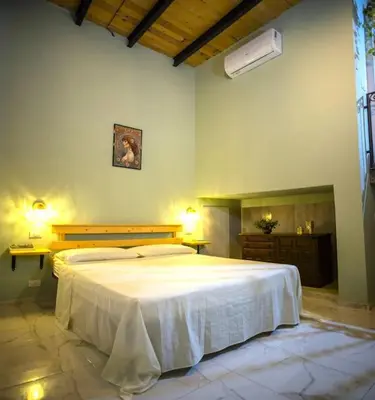 a bedroom with a large white bed in a room at Normanni Underground in Palermo