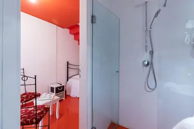 a bathroom with a shower and a bedroom at Olivella 11 in Palermo