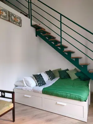 a bedroom with a bed under a staircase at Liberty Green House in Palermo