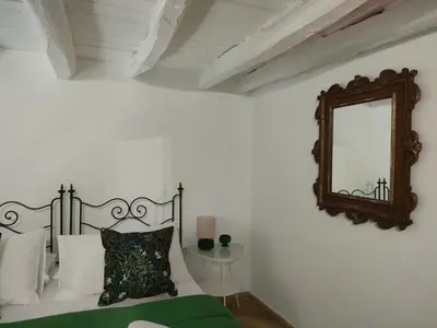 a white bedroom with a bed and a mirror at Liberty Green House in Palermo