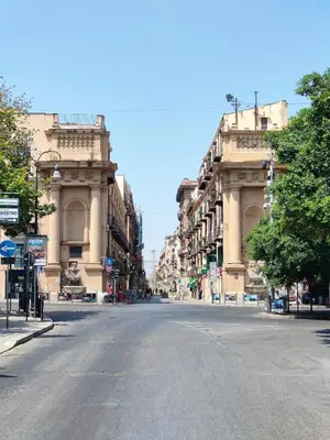 an empty street in a city with tall buildings at Liberty Green House in Palermo