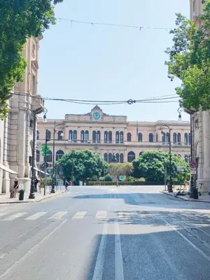 an empty street in front of a large building at Liberty Green House in Palermo