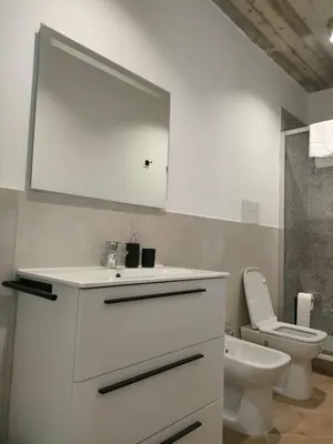 a white bathroom with a sink and a toilet at Liberty Green House in Palermo
