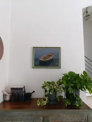 a painting of a boat on a wall with plants at Liberty Green House in Palermo