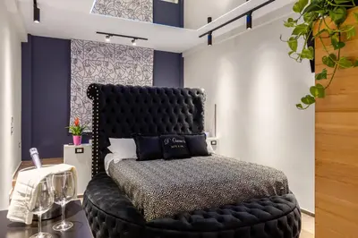 a bedroom with a black bed with a black headboard at D'ossuna66 Suite & Spa in Palermo
