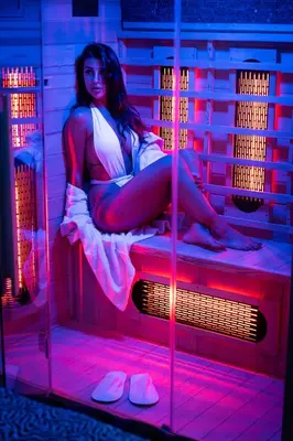 a woman sitting on a bed in a room with red lights at D'ossuna66 Suite & Spa in Palermo