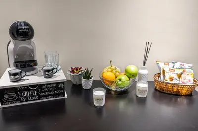a counter with a coffee machine and a bowl of fruit at D'ossuna66 Suite & Spa in Palermo