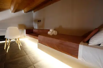a bedroom with a bed and a chair in it at Spera Luxury Palermo & SPA in Palermo