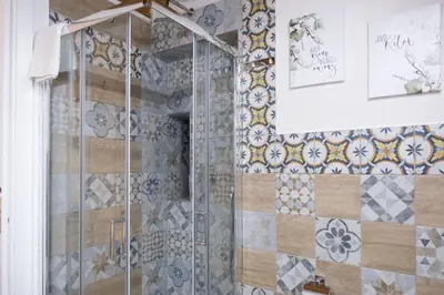 a bathroom with a shower with tiles on the wall at Tra i vicoli di Ballarò in Palermo