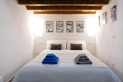 a bedroom with a white bed with blue towels on it at Tra i vicoli di Ballarò in Palermo