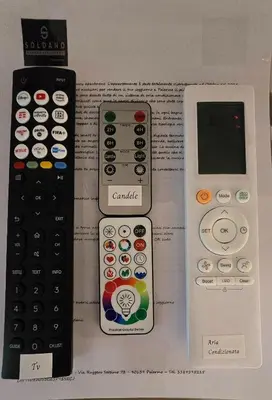 three remote controls sitting on top of a book at Soldano luxury apartment in Palermo