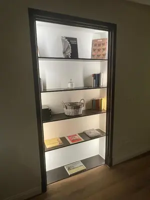 a refrigerator door is open to a shelf with books at Soldano luxury apartment in Palermo