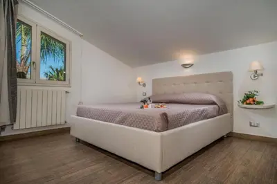 a bedroom with a large bed and a window at Borgo Aranci - Villa Nicales in Castellammare del Golfo