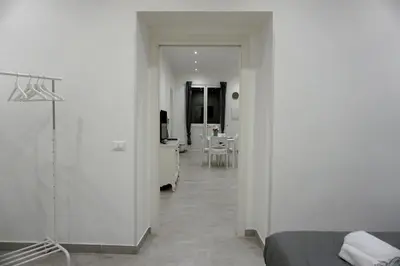 a white room with a bed and a desk at 27 Apartaments Palermo in Palermo