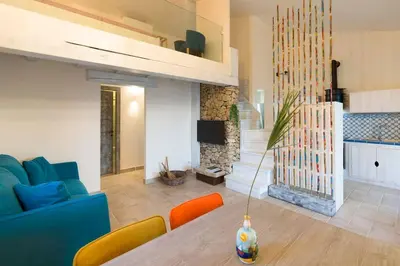 a living room with a blue couch and a table at Villa Faraglioni Cala Bianca in Castellammare del Golfo
