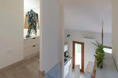 a white room with a staircase and a mirror at Villa Faraglioni Cala Bianca in Castellammare del Golfo