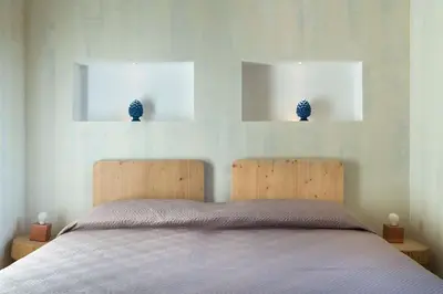 a bedroom with a bed with two blue vases on the wall at Villa Faraglioni Cala Bianca in Castellammare del Golfo