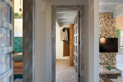 a hallway with a door leading into a room with a bathroom at Villa Faraglioni Cala Bianca in Castellammare del Golfo