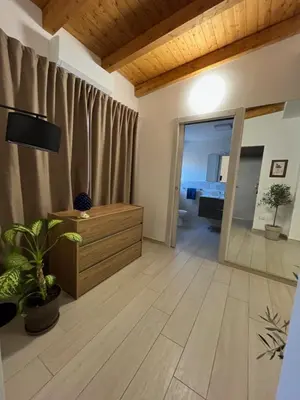 a living room with a television and a mirror at La Terrazza di Nela in Bagheria