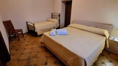 a hotel room with two beds and a chair at Casale di Sicilia in Monreale
