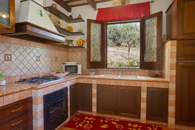 a kitchen with a sink and a window and a stove at Villa Ninetta in Scopello