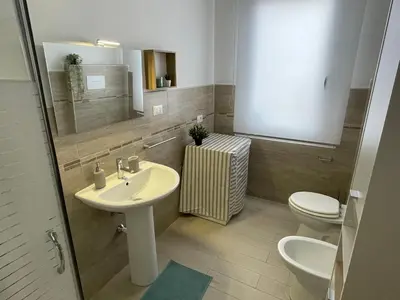 a bathroom with a sink and a toilet and a mirror at Quintino Sella 41 Apartment in Palermo