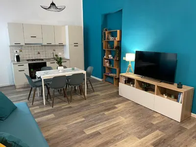 a living room with a dining table and a television at Quintino Sella 41 Apartment in Palermo